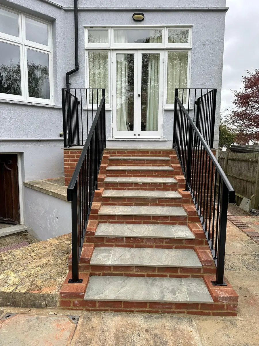 Front steps in porcelain with black railings
